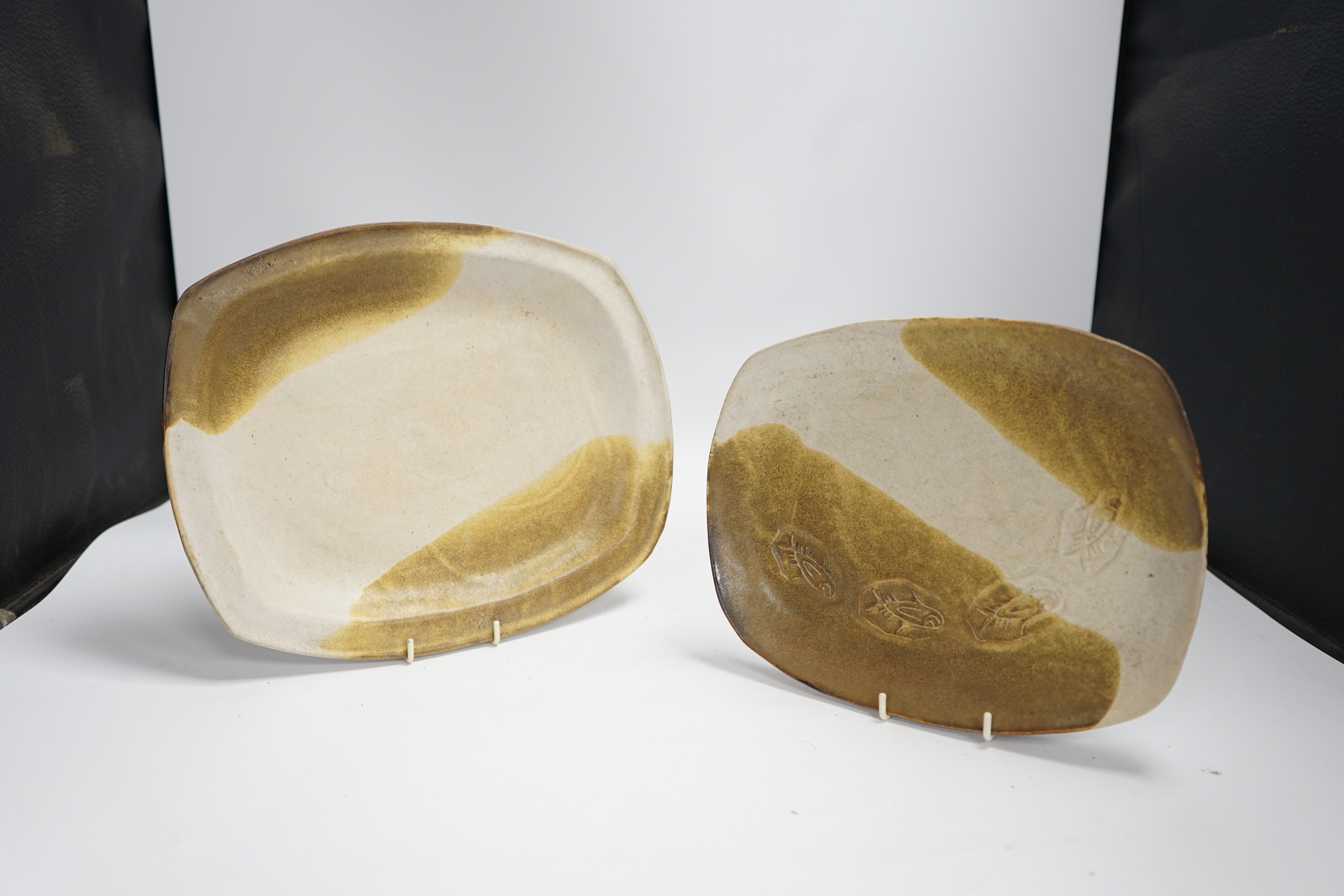 A set of nine studio pottery plates together with a slipware dish, 46cm long